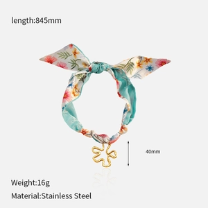 Detail of blue floral silk scarf necklace with gold stainless steel flower pendant