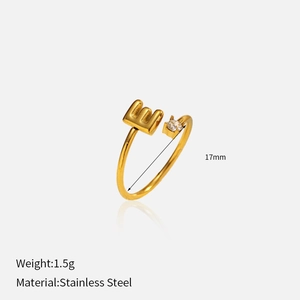 Détail d'une bague lettre E plaquée or 18k avec pierre de zircon et finition acier inoxydable