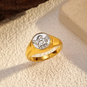 Makroaufnahme von vintage PVD 18k Goldring mit silbernem Amor-Relief auf heller Steinfläche