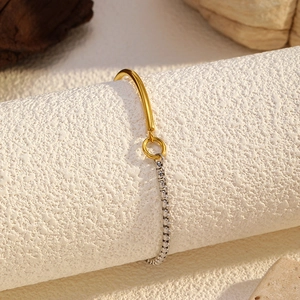 Vue macro du bracelet bicolore minimaliste en or et argent sur un support texturé