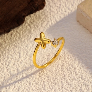 Détail d'une bague ouverte plaquée or 18k avec design en X et pierre de zircon ronde