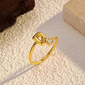 Détail d'une bague ouverte plaquée or 18k avec la lettre D et un zircon étincelant