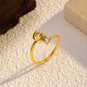 Vue détaillée d'une bague ouverte dorée 18k avec la lettre G et un zircon étincelant