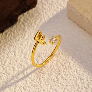 Détail d'une bague ajustable plaquée or 18k avec la lettre F et un zircon cubique