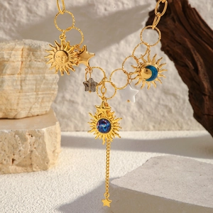 Détail macro du collier étoile de mer plaqué or avec pendentifs célestes sur bois rustique