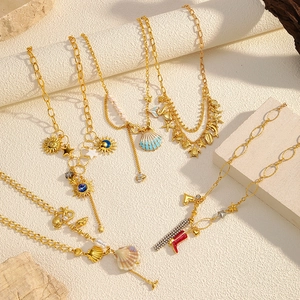 Collier doré thème océan avec pendentifs coquillage et étoile de mer sur socle