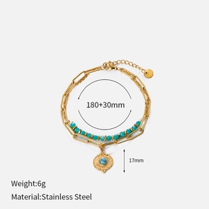 Detail of gold stainless steel layered bracelet with turquoise beads and sunburst pendant