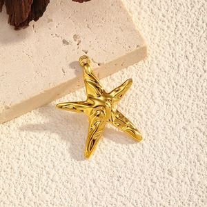 Makro-Detail des vergoldeten Seestern-Anhängers mit 18K Textur und Ring auf Naturstein