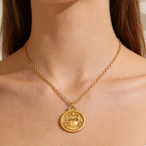 Golden zodiac coin necklace with a crab relief pendant on a classic O-link chain