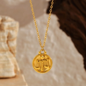 Detailed macro shot of a gold Libra zodiac coin pendant with a matte sandblast finish