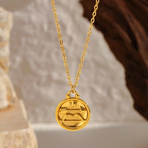 Detailed view of Sagittarius zodiac gold pendant necklace on a natural stone surface