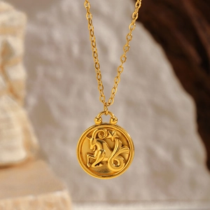 Macro view of gold Capricorn zodiac medallion pendant with fine textured cross chain
