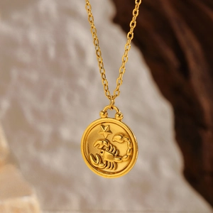 Macro detail of gold plated Scorpio zodiac coin pendant with embossed celestial relief
