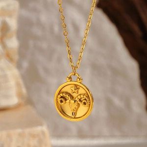 Macro detail of Aries zodiac coin pendant with gold plating and fine embossed ram design