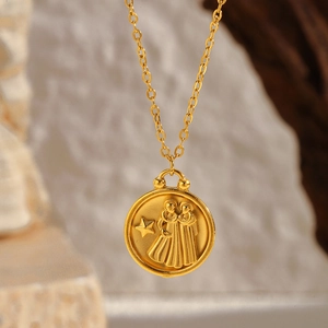 Macro detail of 18K gold-plated zodiac coin pendant with Gemini relief and cross chain