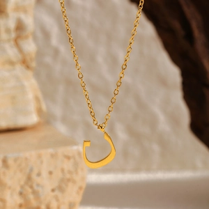 Détail du pendentif lettre arabe en or 18 carats montrant la finition mate élégante
