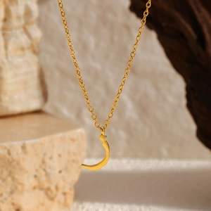 Détail d'un pendentif arabe plaqué or 18 carats sur une fine chaîne en acier inoxydable