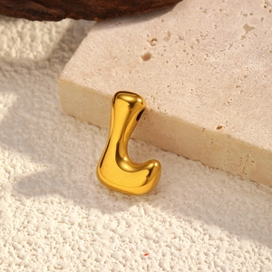 Polished gold irregular letter L pendant on stone textured background for DIY jewelry