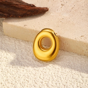 Detailed view of organic oval golden pendant with polished finish and large center hole