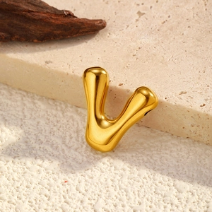 Detailed macro view of a gold-plated V-shaped letter pendant with a smooth bubble design
