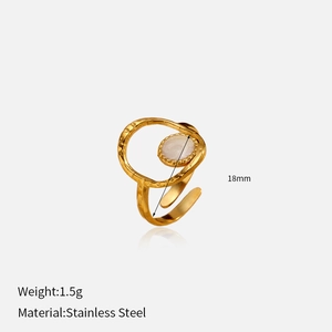 Gros plan d'une bague dorée avec insert blanc et texture en acier inoxydable