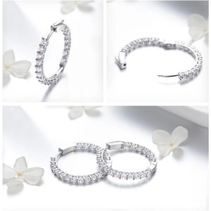 Detail view of silver hoop earrings with clear round cubic zirconia in micro-pave setting