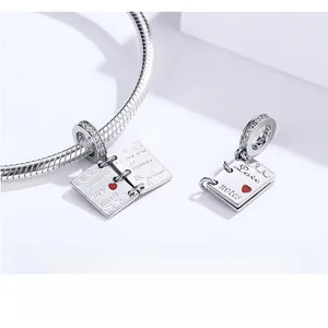 Detailed macro of S925 sterling silver love letter book charm with red enamel heart