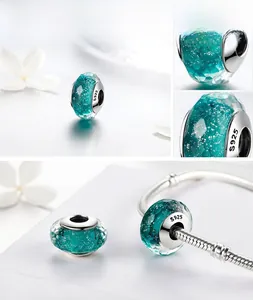 Macro shot of S925 sterling silver faceted green glass charm bead with silver glitter