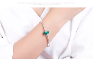 Detailed view of an S925 sterling silver snake chain bracelet with green faceted glass bead
