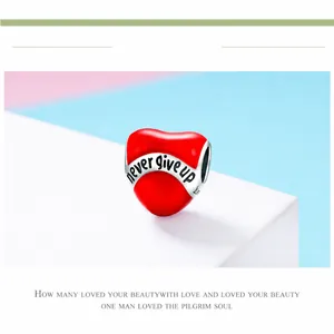 Détail macro du charm coeur en émail rouge avec l'inscription Never Give Up sur pierre