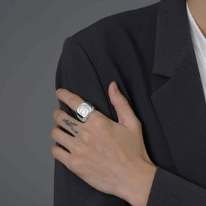 Close-up of a stainless steel signet ring with engraved basketball motif on male finger