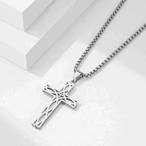 Detailed macro view of silver hollow patterned cross pendant with a square box chain link