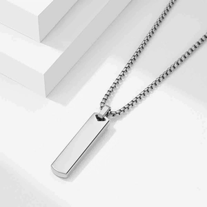 Détail du pendentif rectangle argenté avec chaîne perle sur fond géométrique blanc