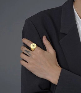 Close-up of gold signet ring featuring engraved Freemasonry symbol on a flat top