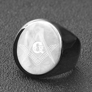 Macro close-up of a black Freemasonry signet ring featuring the square and compass symbol