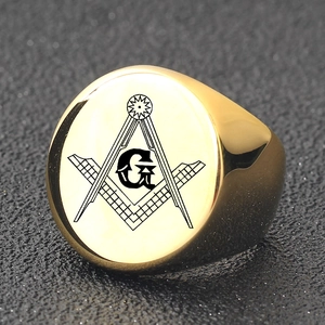 Macro detail of golden Freemason signet ring with engraved G symbol on leather