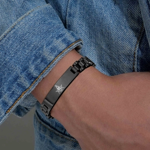 Dettaglio del bracciale massonico in acciaio inossidabile nero con simbolo G su uomo