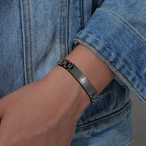 Dettaglio macro del bracciale da uomo in acciaio inossidabile nero opaco con simbolo massonico