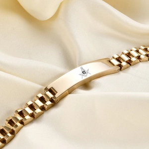 Macro di un bracciale in acciaio inossidabile dorato con incisione del simbolo massonico G
