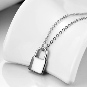 Détail du pendentif cadenas en argent sur une fine chaîne au fini poli minimaliste