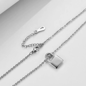 Gros plan détaillé de la gravure 18KGP sur le fermoir du collier à pendentif cadenas