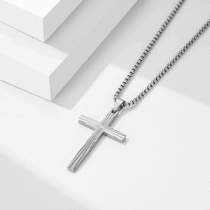 Macro detail of 50mm vintage cross pendant with sunburst texture and box chain