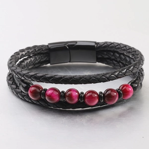 Detalle de pulsera de cuero trenzado negro multicapa con cuentas rojas y cierre magnético