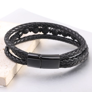 Detalle de pulsera multicapa de cuero negro con cuentas de lava y cierre metálico imán