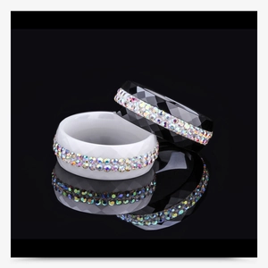 Macro detail of black and white ceramic rings with double-row sparkling crystal inlay