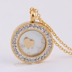 Détail macro du collier médaillon doré avec strass scintillants et breloque en cœur