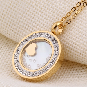 Détail d'un pendentif rond doré de 30mm avec strass et motif de cœur évidé élégant