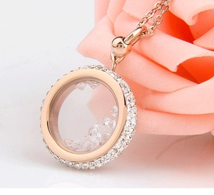 Macro shot of rose gold floating locket necklace with white crystals on pink petals