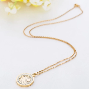 Gros plan d'un médaillon rond doré de 30mm avec diamants flottants et petit cœur