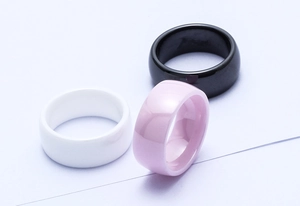 Detail of 8mm polished ceramic rings in black, white, and pink with mirror finish